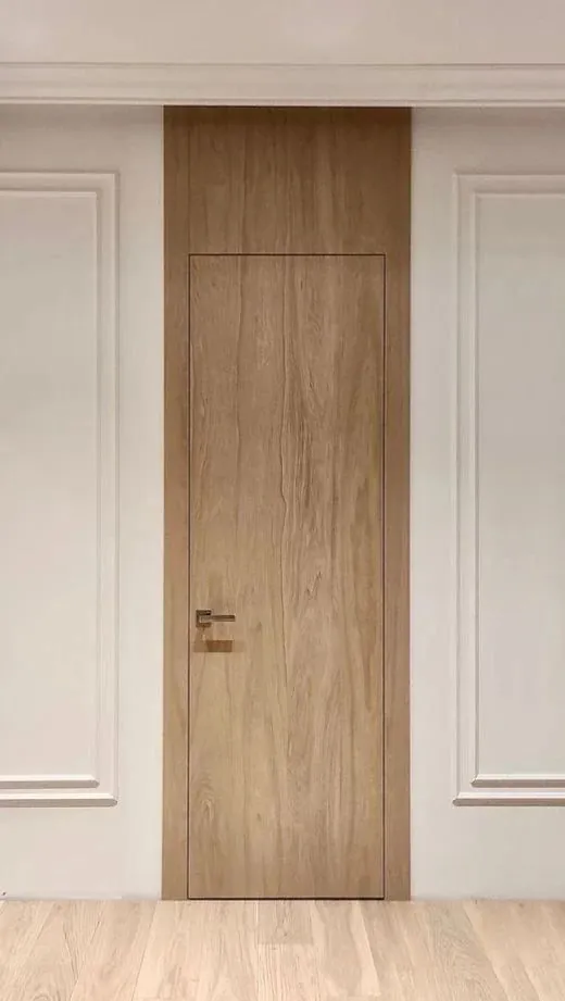 Puerta enrasada en una pared con molduras